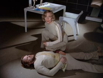 In a darkened sick bay, Barbara is crouched, looking up at us. Lying on the ground in front of here is the frozen body of a bearded young man.