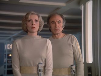 Barbara and Victor are standing together, shoulder to shoulder, in a room on Moonbase Alpha. Victor looks quite concerned, while Barbara is thoroughly startled