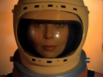 Bathed in yellow light, Barbara is staring at us in extreme closeup, looking unhinged.